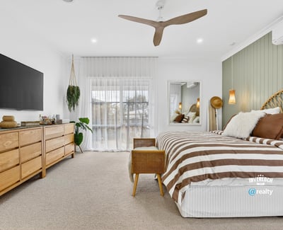 Bright and spacious bedroom featuring natural wood accents, large windows, and modern amenities for comfort.
