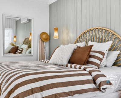 Cozy bedroom featuring a unique headboard, striped bedding, and modern accents for a relaxed atmosphere.