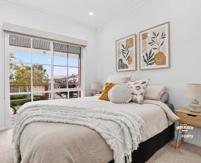 Bright and inviting bedroom featuring large windows, modern decor, and a cozy atmosphere for relaxation.