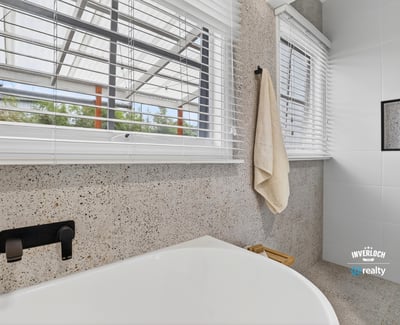 Bright and modern bathroom featuring a spacious tub and large windows for ample natural light.