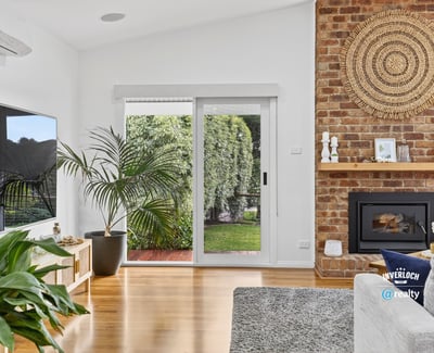 Bright living space featuring a cozy fireplace, modern amenities, and seamless indoor-outdoor access.