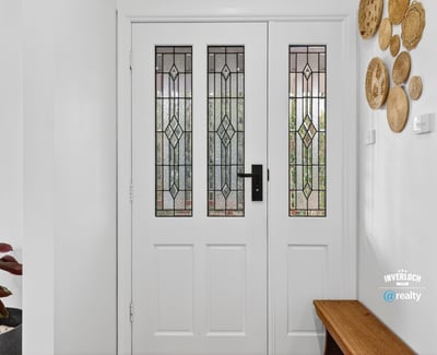 Inviting entryway featuring detailed glass doors and unique wall decor, perfect for welcoming guests.