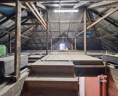 Spacious attic with exposed beams, offering limitless potential for customization or creative use.