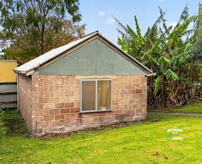 This property offers a unique renovation opportunity amid a spacious backyard surrounded by lush greenery.