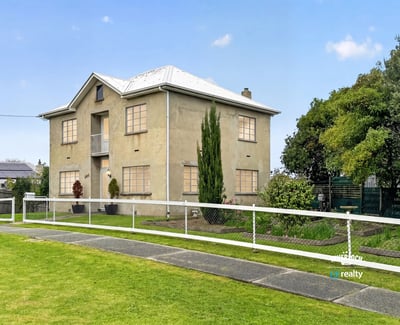 This spacious two-story home features large windows, a manicured lawn, and ample outdoor space for gatherings.