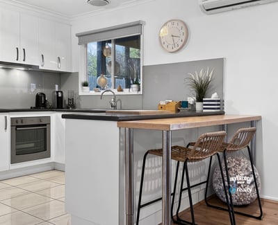 Modern kitchen featuring sleek cabinetry, a cozy breakfast bar, and ample natural light for culinary inspiration.