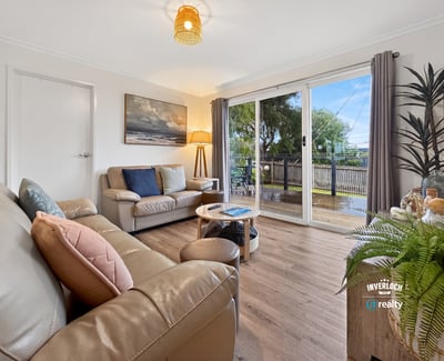 Bright and inviting living space featuring large windows, a cozy atmosphere, and easy outdoor access.