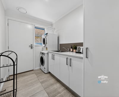 Bright and functional laundry area featuring modern appliances and practical storage solutions to enhance convenience.