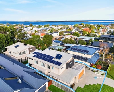 Modern home featuring solar panels and picturesque views, nestled in a vibrant coastal community.