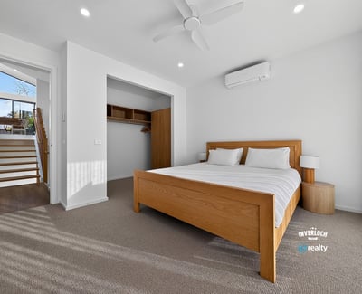 Bright and airy bedroom featuring a spacious layout, modern air conditioning, and abundant natural light.