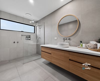 This modern bathroom features a spacious design, sleek finishes, and natural light from a large window.