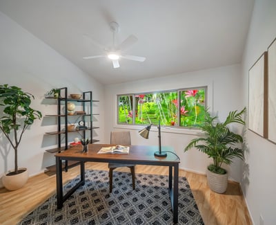 Bright home office featuring a large window, natural light, and vibrant views of lush greenery.