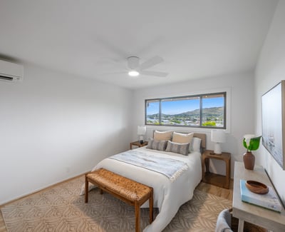 Bright and spacious bedroom featuring large windows with scenic views and modern furnishings for comfort.