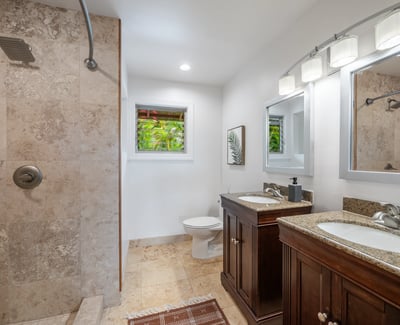Modern bathroom featuring dual sinks, a spacious walk-in shower, and natural light from adjacent windows.