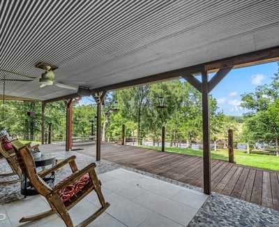 Spacious covered porch overlooking lush greenery, perfect for relaxation and outdoor gathering opportunities.