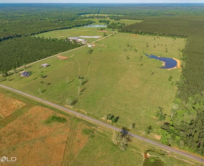 Spacious rural property featuring expansive pastures, a tranquil pond, and scenic views, ideal for development or recreation.