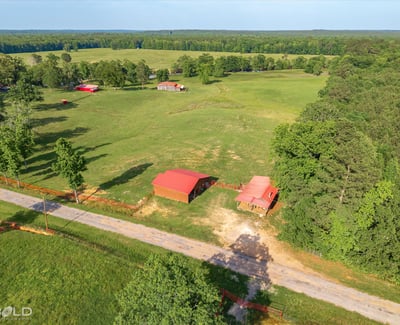 Spacious rural property featuring open fields, multiple outbuildings, and scenic views, perfect for your dream home.