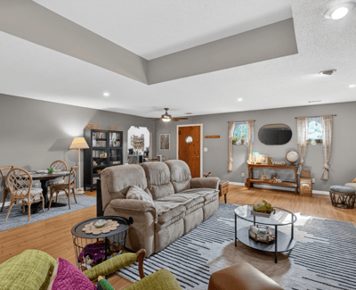 Spacious living area features modern decor, ample natural light, and versatile seating for relaxation or gatherings.