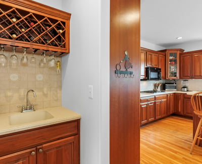 Butlers Pantry with convenient wine rack, glassware storage, wet bar, and prep area.