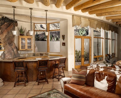 Host unforgettable gatherings at this custom wet bar, beautifully integrated into the open-concept great room. Natural stone accents, warm wood cabinetry, and views of the tranquil Zen garden create a perfect harmony of indoor luxury and outdoor serenity.