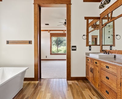 Spa inspired bathroom featuring a dual vanity, natural wood cabinetry, quartz counters, and modern fixtures. A luxurious and functional primary bath in this Phoenix residence.