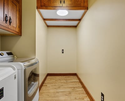 Functional laundry room offering overhead cabinetry, storage space, and durable finishes. Designed to support organization and efficiency.
