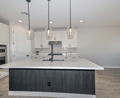 Enjoy cooking in style with premium stainless appliances, an oversized island, chic pendant lights, and designer tile backsplash.