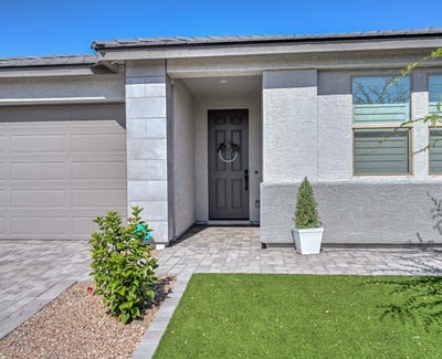 Enter through a clean-lined portico with upgraded trim, neutral tones, and thoughtfully landscaped greenery in front.