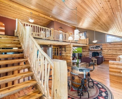 View from the staircase showcasing log railings, expansive living space, and seamless flow between levels for everyday living and entertaining.