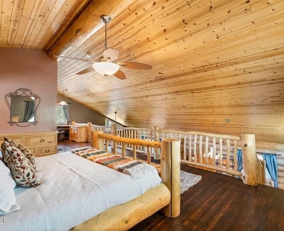 Owner s bedroom offering space for seating, natural light, and rustic finishes that enhance comfort and livability.