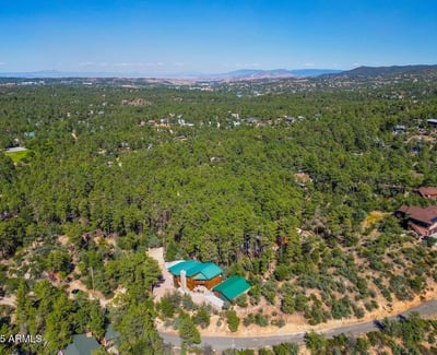 Panoramic aerial image capturing miles of forest and valley beyond the home. This view highlights the elevated position and scenic beauty that define this exceptional Prescott property.