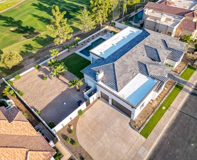 Aerial view highlights the pool, patio, and green lawn, showcasing the home s outdoor living and entertaining spaces.