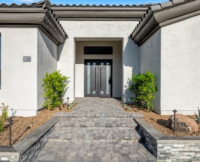 A modern stone-paved entry leads to sleek double doors, giving this Scottsdale property standout curb appeal.