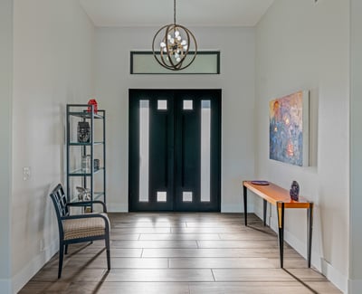 The foyer welcomes guests with updated tile flooring, designer lighting, and contemporary Scottsdale design details.