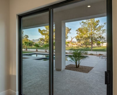Sliding doors in the main bedroom highlight stunning pool, mountain, and golf course views in Scottsdale.