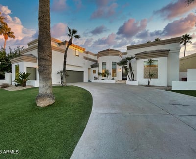 Beautiful modern architecture framed by palms and desert landscaping. The curved drive and tall windows make a bold Scottsdale impression.