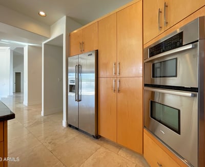 Sleek kitchen featuring premium stainless appliances and warm maple cabinetry combining efficiency with contemporary Scottsdale design.
