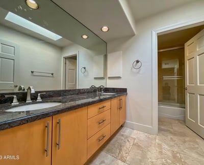 Refined guest bath with dual-sink vanity, granite surfaces, and soft neutral tones. Perfectly balanced between style and function.