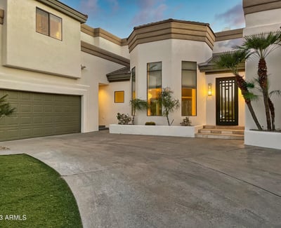 Elegant architectural lines and soft lighting frame this inviting front entrance with timeless desert charm.