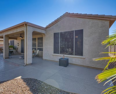 Enjoy the comfort of this covered patio space, complete with ceiling fan and desert views ideal for relaxation or casual gatherings.