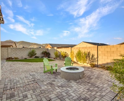 A fire pit area surrounded by desert greenery and mountain views adds charm and tranquility to this Litchfield Park backyard.
