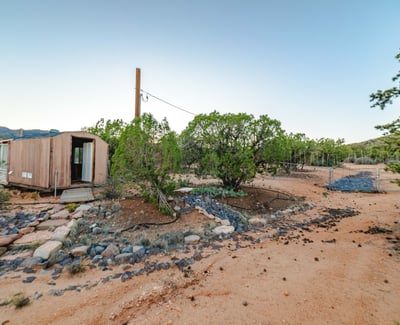 Expansive open space with mature vegetation offers endless possibilities for outdoor activities, workspaces, or creative land use on this Hackberry retreat.