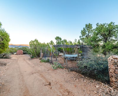 A fenced-in structure is perfect for gardening, small animals, or equipment. Naturally shaded and surrounded by trees, it blends seamlessly with Hackberry terrain.