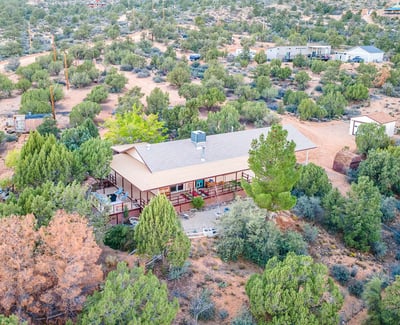 An inviting aerial showcases the property s serene placement among natural vegetation, offering privacy, mountain views, and ample usable land for future vision.