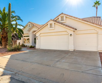 Spacious driveway leading to a three-car garage, offering convenient parking and storage options. The clean exterior lines and updated Scottsdale home design provide both functionality and visual appeal.