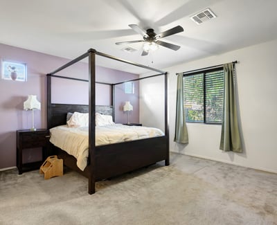 Primary bedroom featuring soft carpet, ceiling fan, and generous floor space, creating a relaxing and private sleeping area.