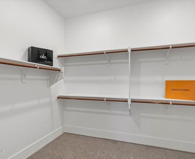 Well-designed walk-in closet with shelving and hanging areas, offering excellent storage and organization.