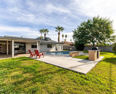 Beautiful backyard scene with a private swimming pool, shaded patio, and plenty of room to host an ideal outdoor setup in this Phoenix home for sale.