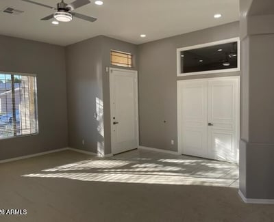 Living room filled with natural light from multiple windows, highlighting the open floorplan and updated interior finishes.