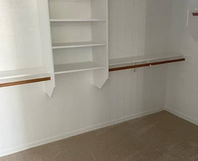 Walk-in closet featuring custom shelving and hanging space, offering efficient storage and easy organization for wardrobes of any size.